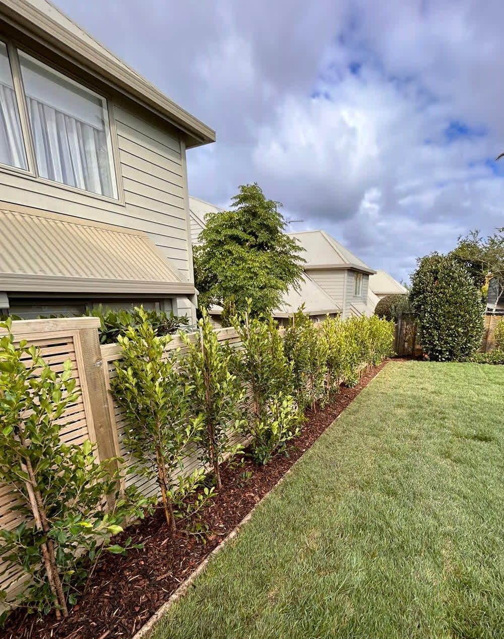 Tiny garden bordered by horizontal wooden fence